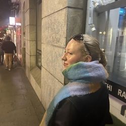 Photo of Anna G wearing a scarf on a sidewalk in Madrid