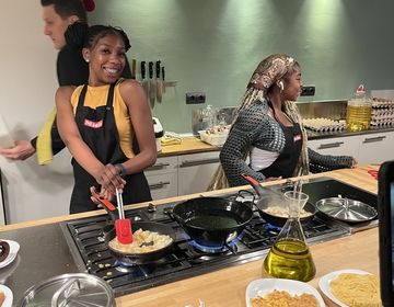 A student smiling while cooking
