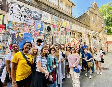 Street Art tour group photo in front of wall covered in art