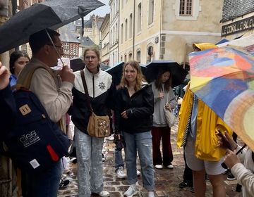 students listening to the program leader in the rain