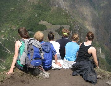 Group of people sitting on ridge overlooking mountain in Chile