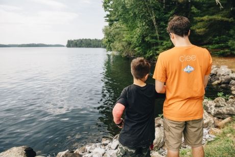 Counselor and kid standing by the water