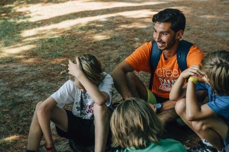 Camp Exchange USA counselor sitting with group of kids