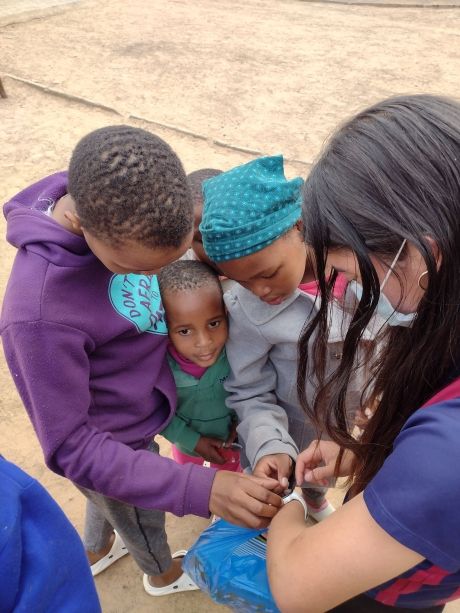 High school student with kids in Gaborone inspecting her watch