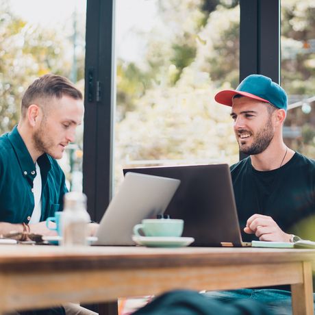 auckland two young men on laptops at long table