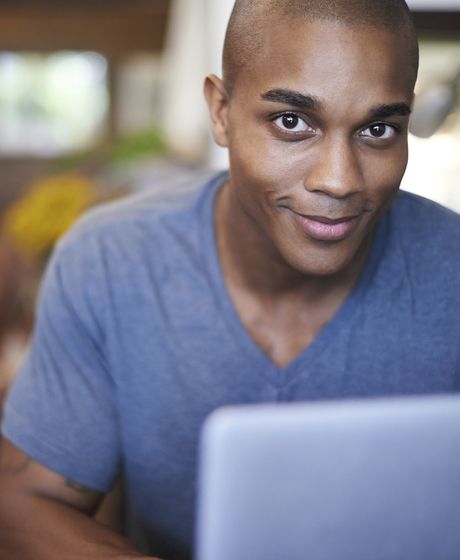 Young man smiling over laptop