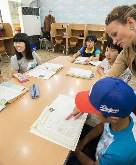 A intern teacher works with her students in the classroom