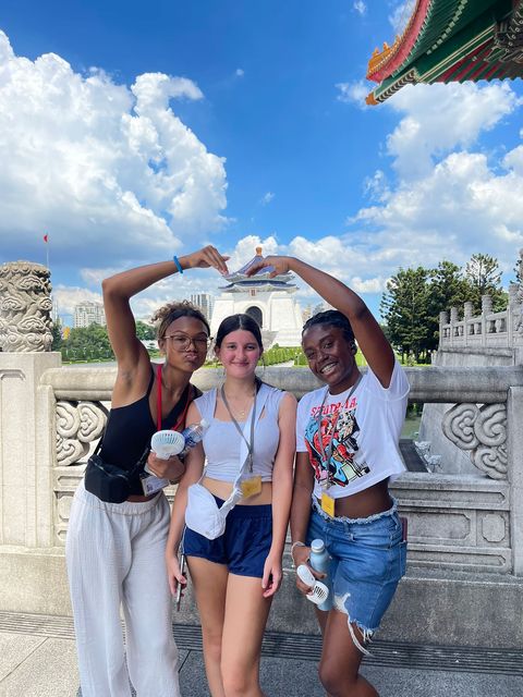 High school girls heart posing in front of a temple