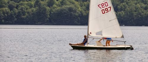 Kids sailing on the lake at summer camp