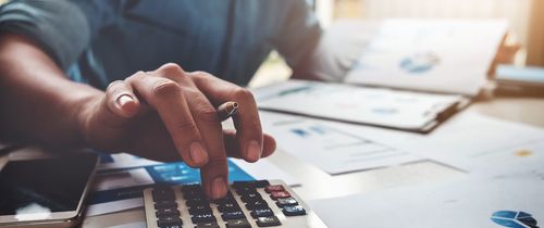 Business man with a calculator looking at financial documents