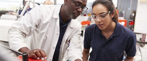 A female intern listens to instructions from her teacher