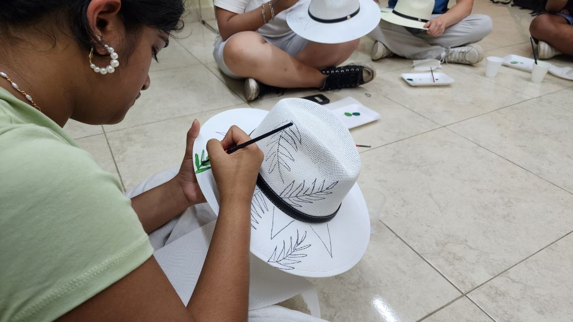 Student painting a hat