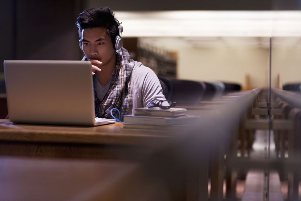 Student on laptop in dark library