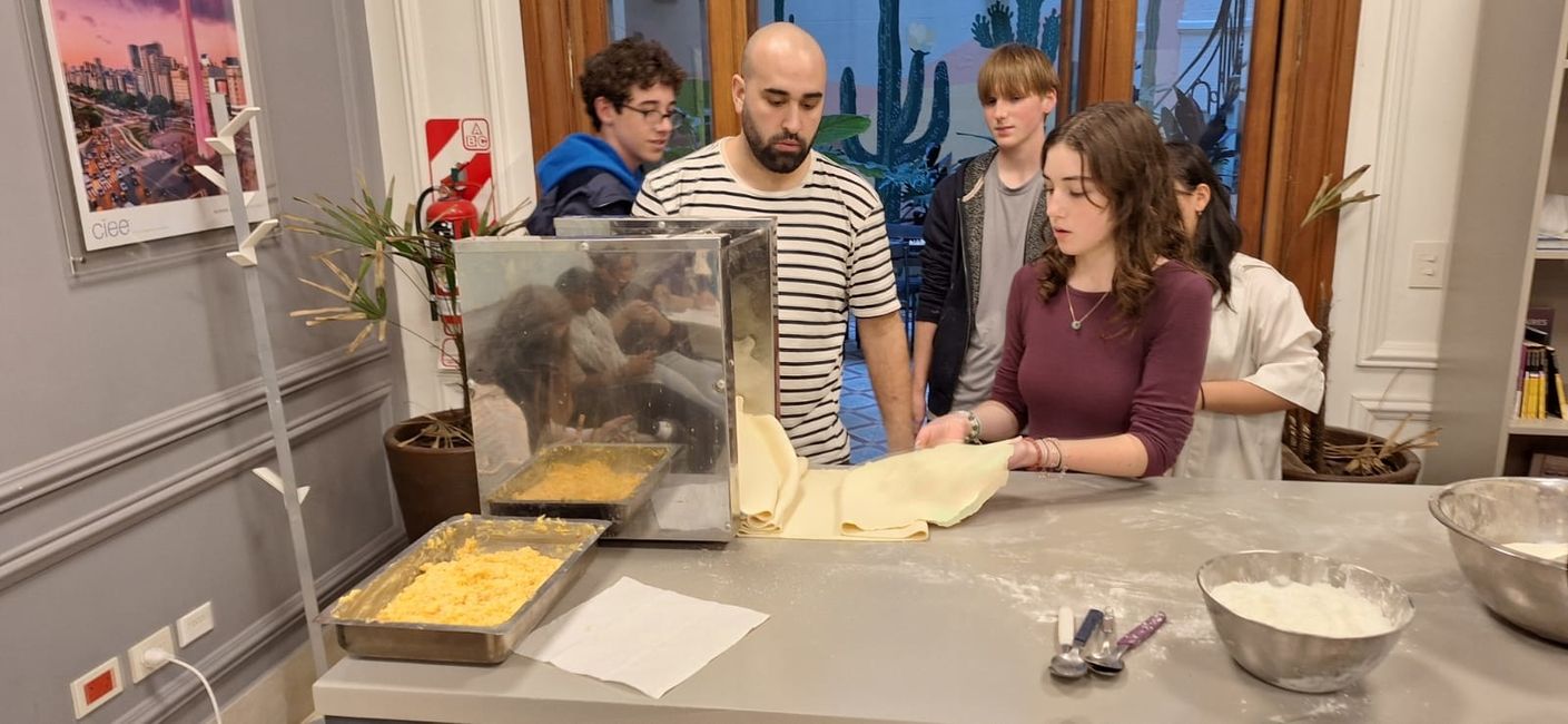 Phoebe takes the flattened dough out of the machine.