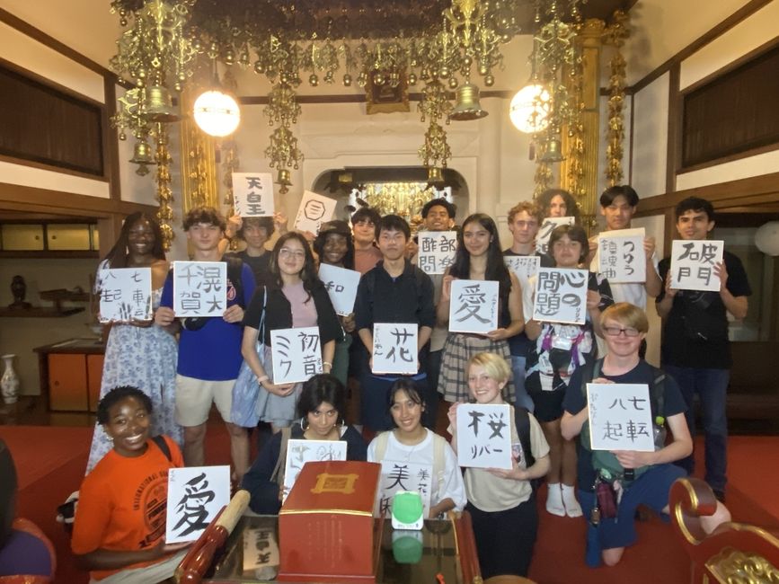 Students posing in front of the shrine with their finished Shodo works!