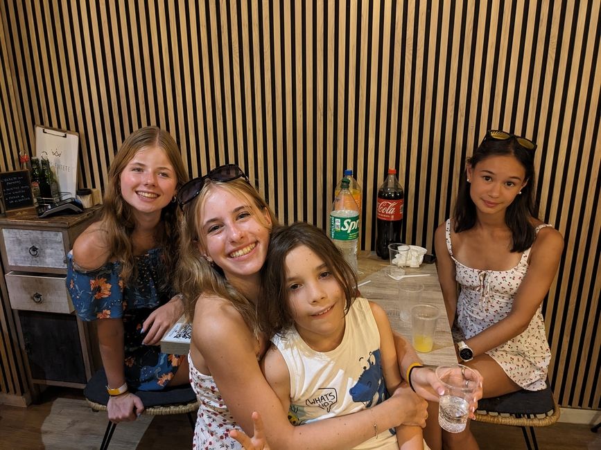 Three students smile at the camera with their host sister