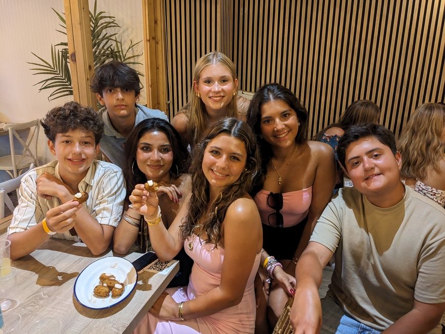 Students sitting at a table with croquettes smile