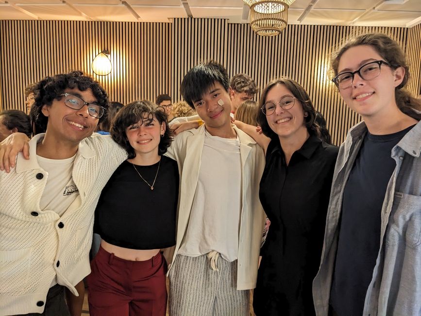 Five students stand together and smile