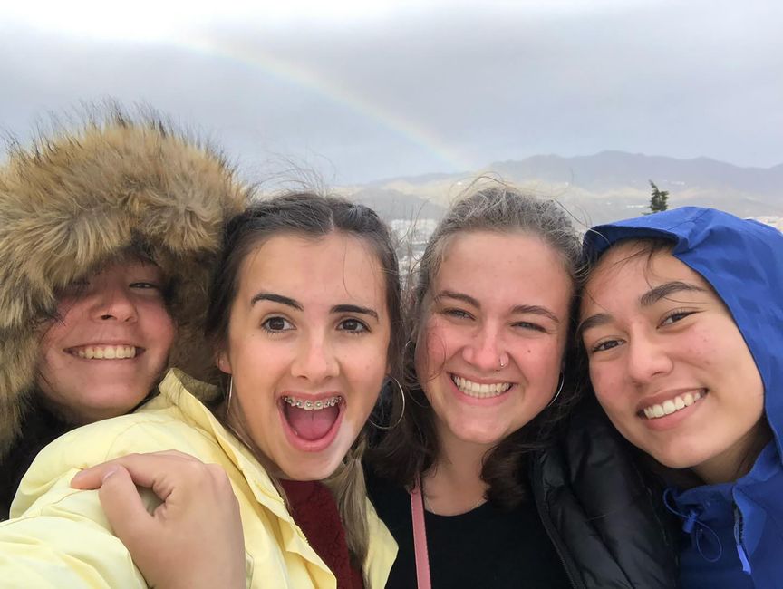 Students taking a photo in front of a rainbow in Spain