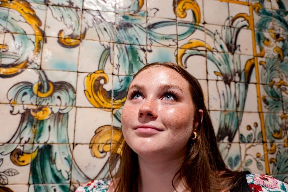 Student next to a tile mural