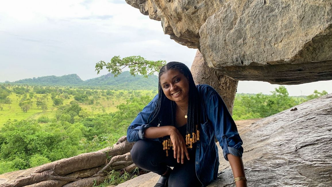 legon girl sitting on rock