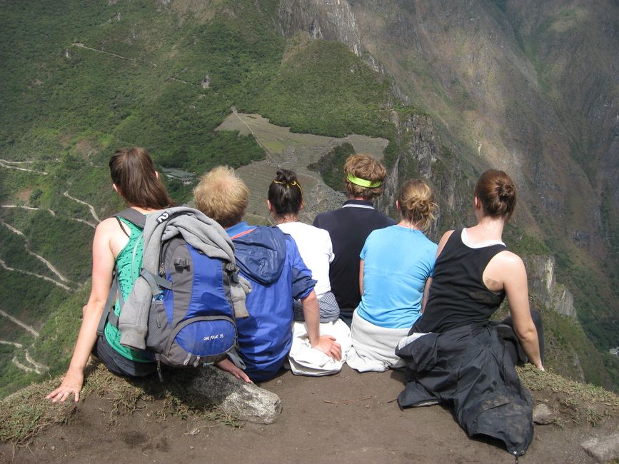 Group of people sitting on ridge overlooking mountain in Chile