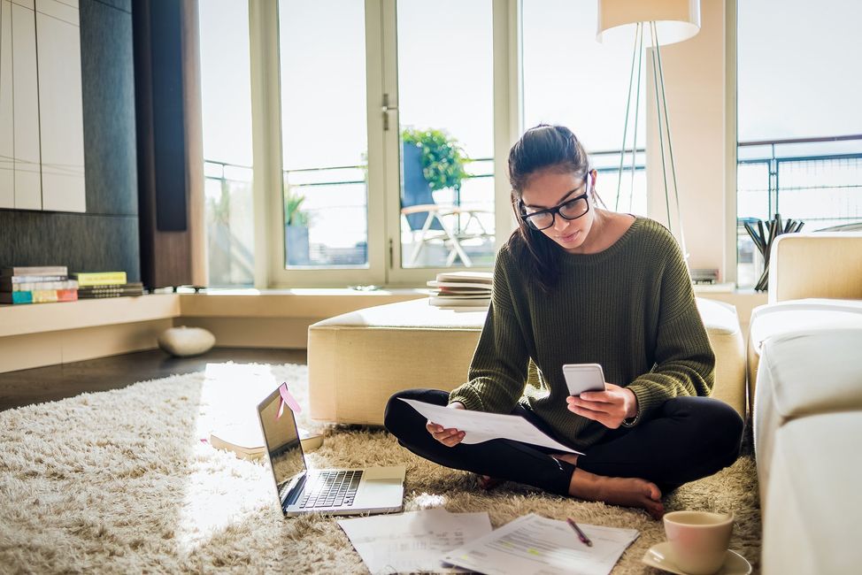 Young woman on her phone with her laptop out before her