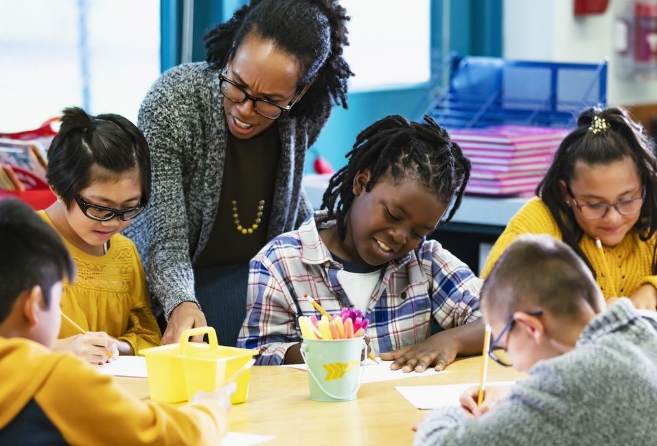 Teacher working with a group of students (age 8-10) in a classroom setting