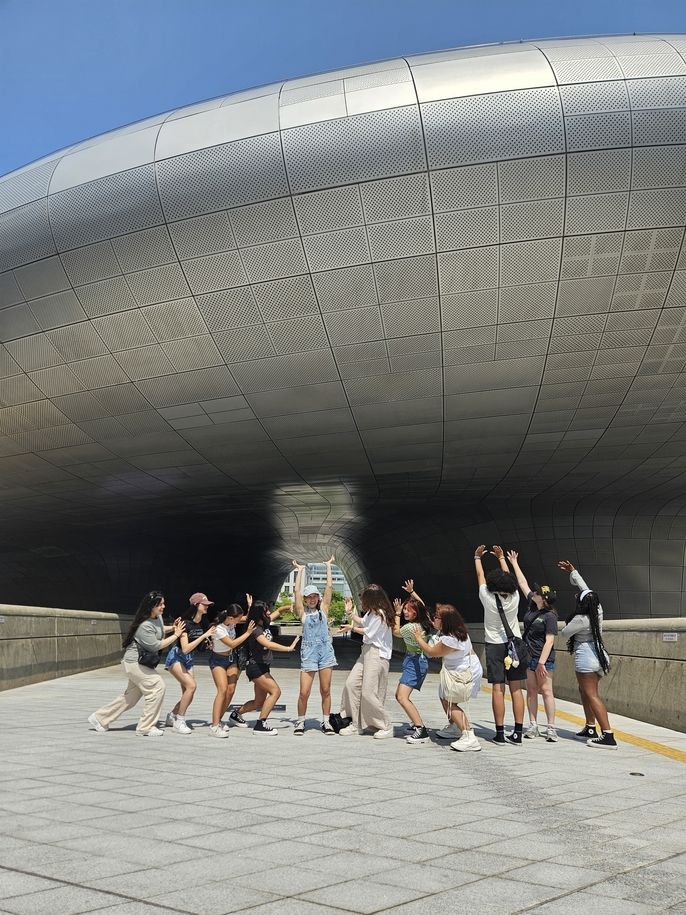 Students on scavenger hunt posing at Dongdaemun Design Plaza 