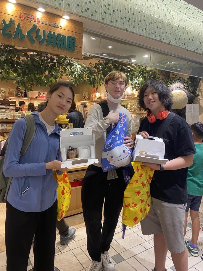 Global Navigators show off sweet treats from the Kirby Cafe while standing in front of the Studio Ghibli store at Tokyo Character Street.