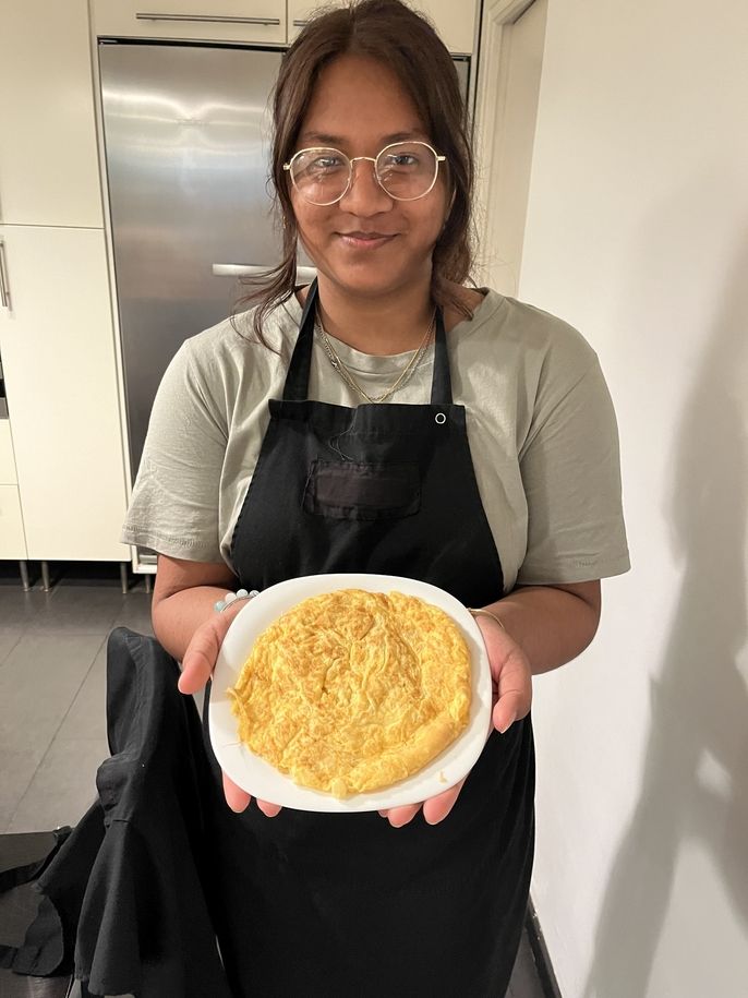 A proud student holding up her Spanish omelette. 