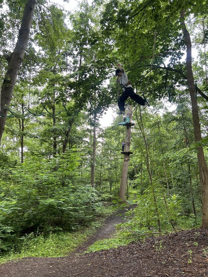 Fashion and Design student Bomin Park is suspended in the air on a swinging Accrobranche obstacle. 