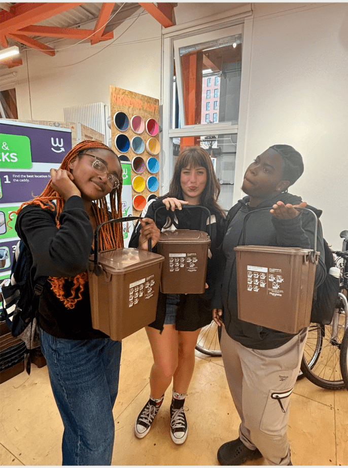 Students displaying their sustainable/reusable food storage bins