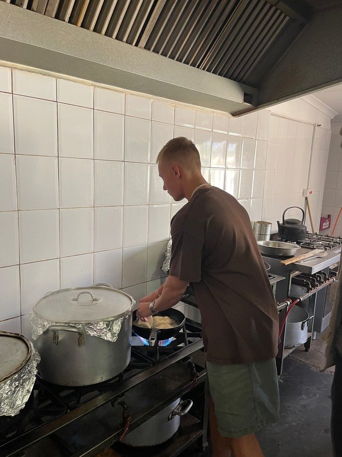 Carefully putting the fat cakes into hot oil.