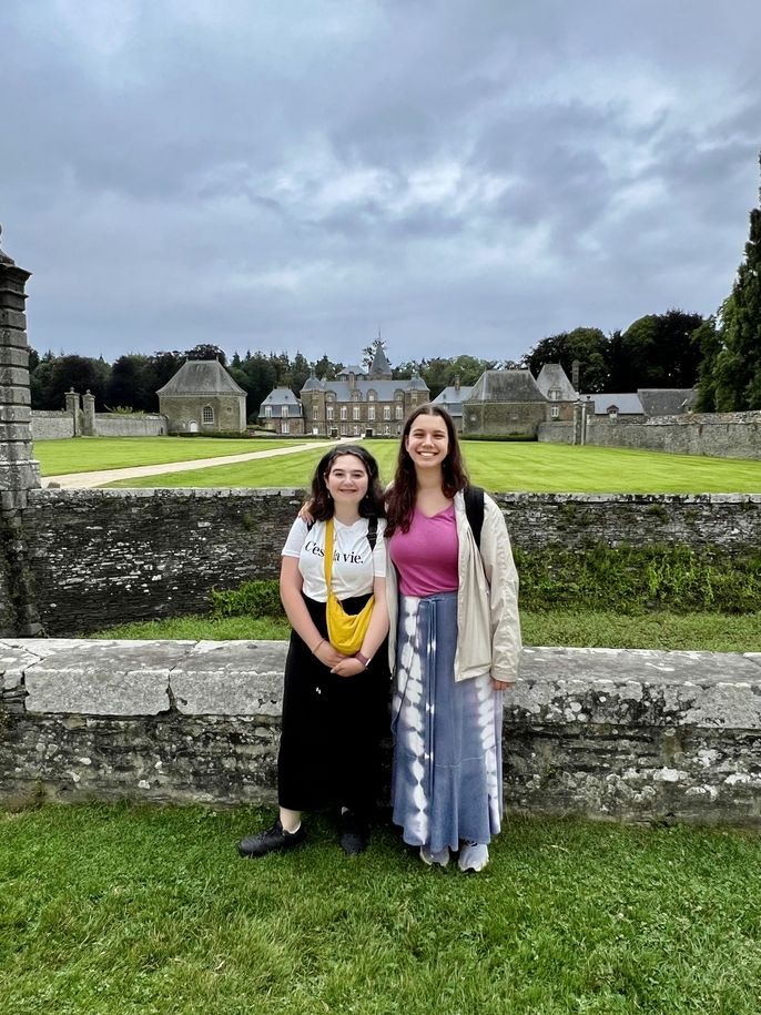 two female teens standing in front of the chateau