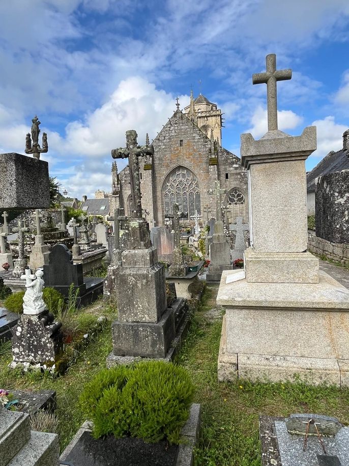 Headstones with with Locronan cathedral in the background.