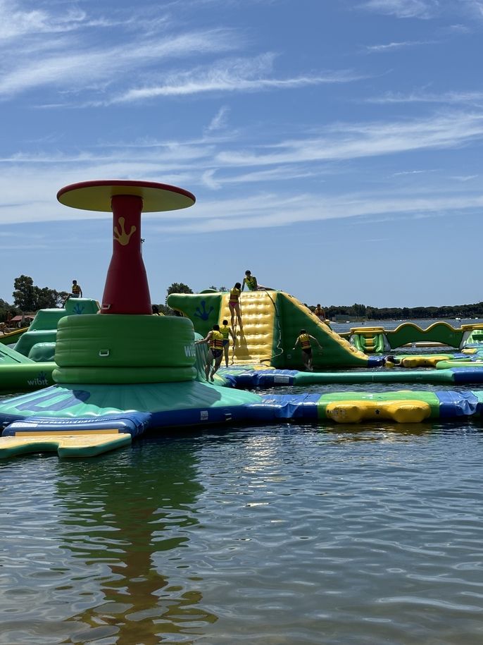 Students climb on giant inflatable course.