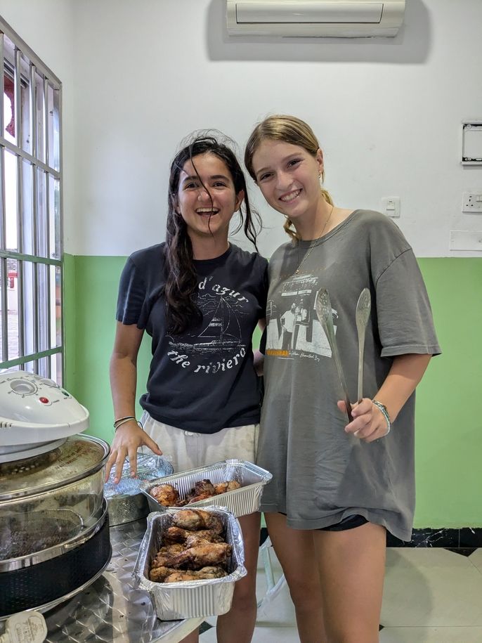 Jillian and Sara pose with the fried chicken they made during the cooking activity.