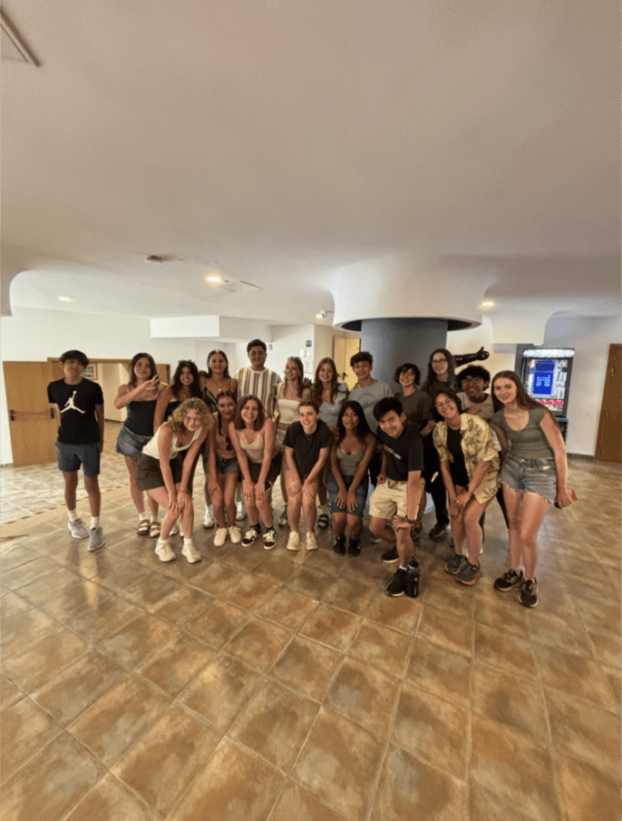 A group of high school students poses for a picture in a hotel lobby