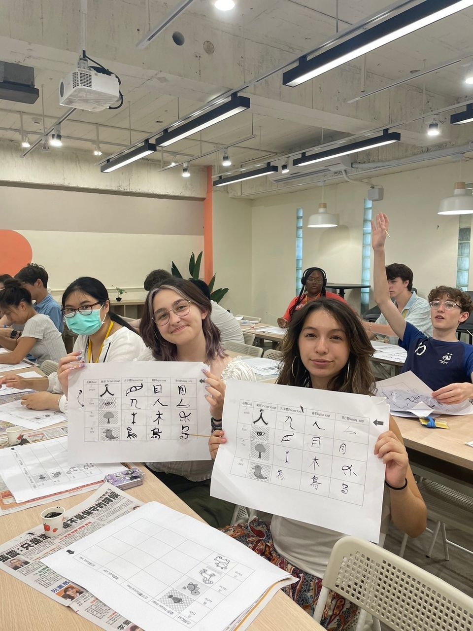 Two students holding up their practice sheets showing character development 